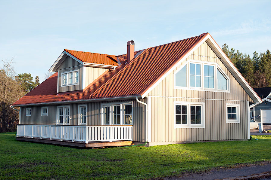 Серый дом с красной крышей и белыми окнами фото